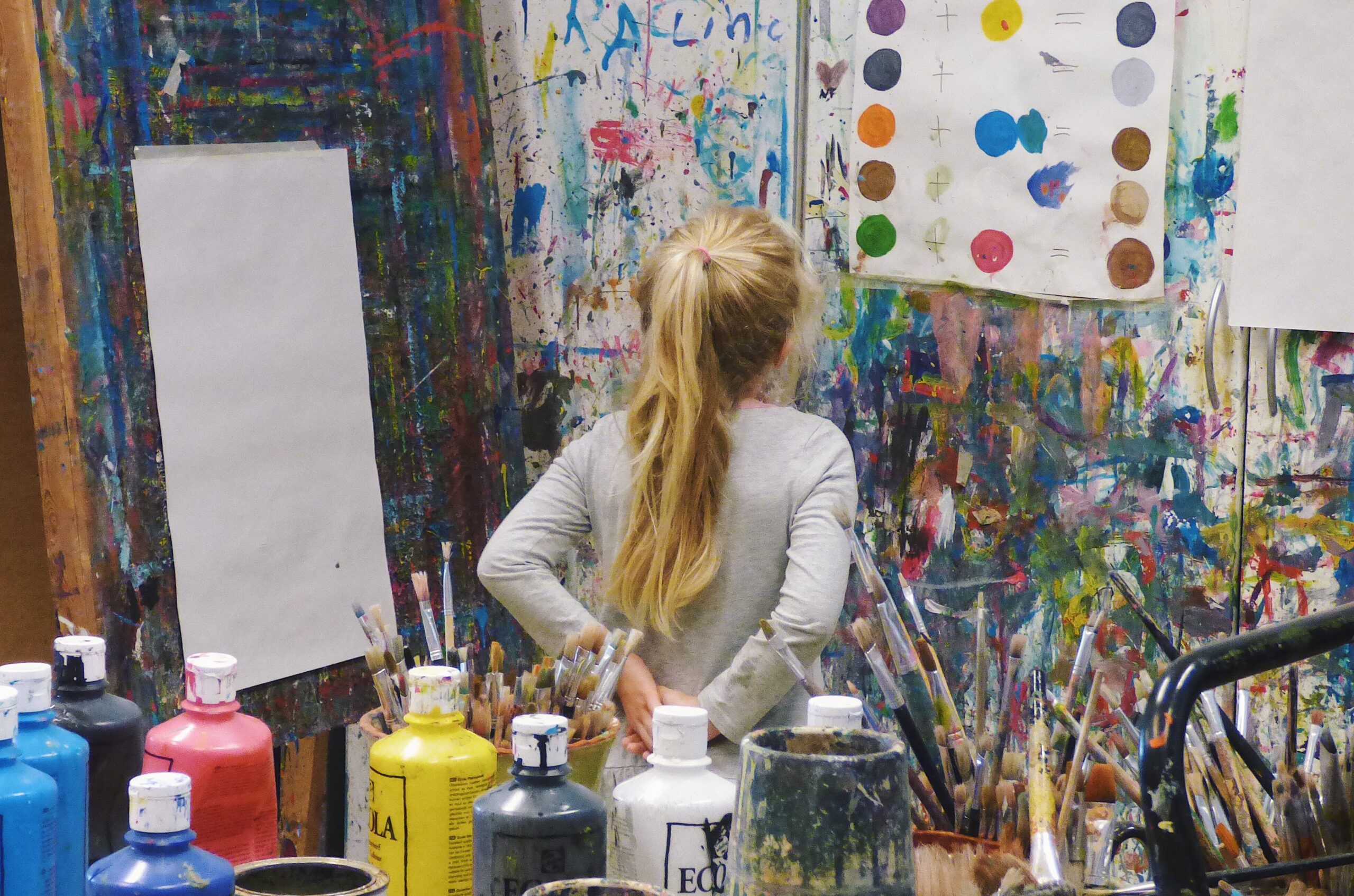 tyttö katselee taideluokan seinällä olevaa värimallia
